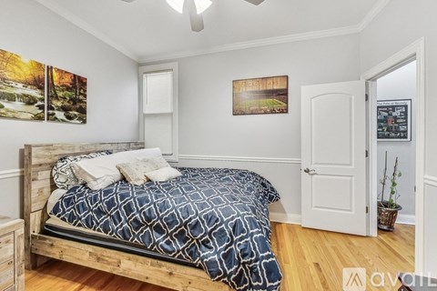 A bedroom with a bed, dresser, and two pictures on the wall.