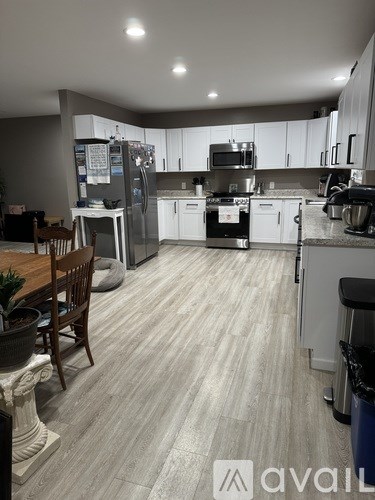 A kitchen with white cabinets and a wooden table.