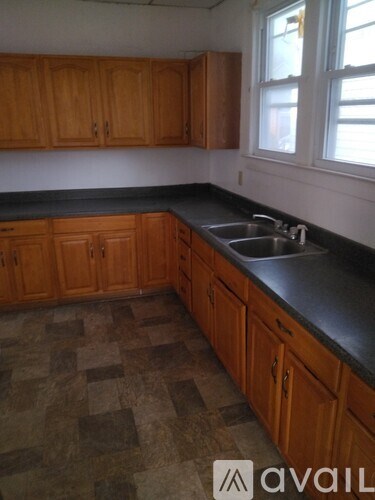 A kitchen with wooden cabinets and a checkered floor.
