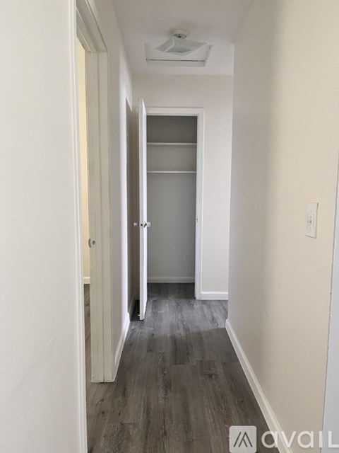 A room with a ceiling fan and a window with blinds.