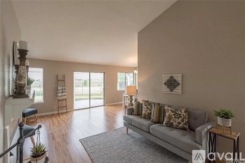 A living room with a grey couch and a wooden floor.