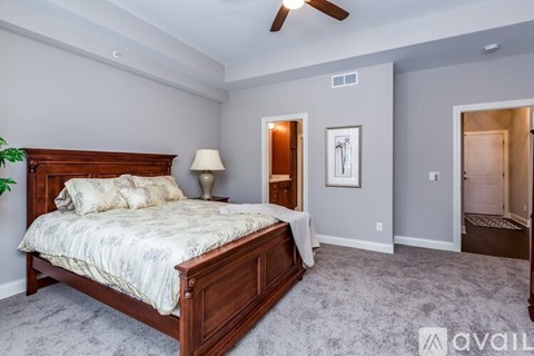 A bedroom with a large bed and a ceiling fan.