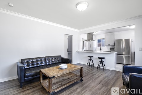 A modern living room with a black leather sofa and a wooden coffee table.
