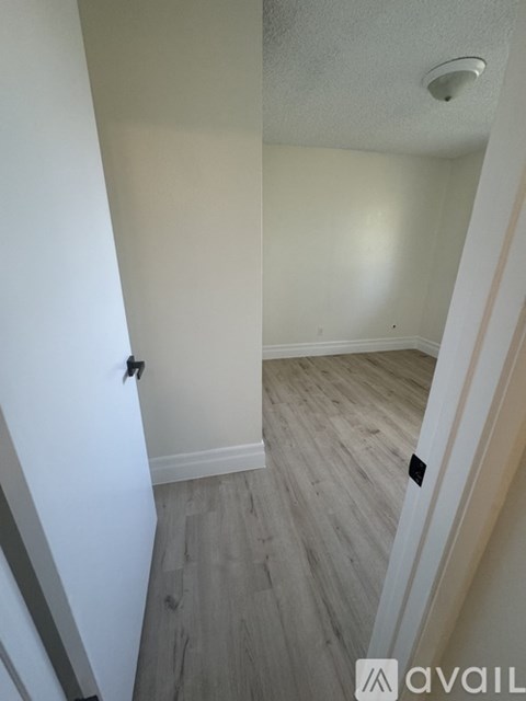 A room with a light colored wall and a wooden floor.