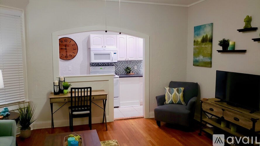 A living room with a chair, a table, and a painting on the wall.
