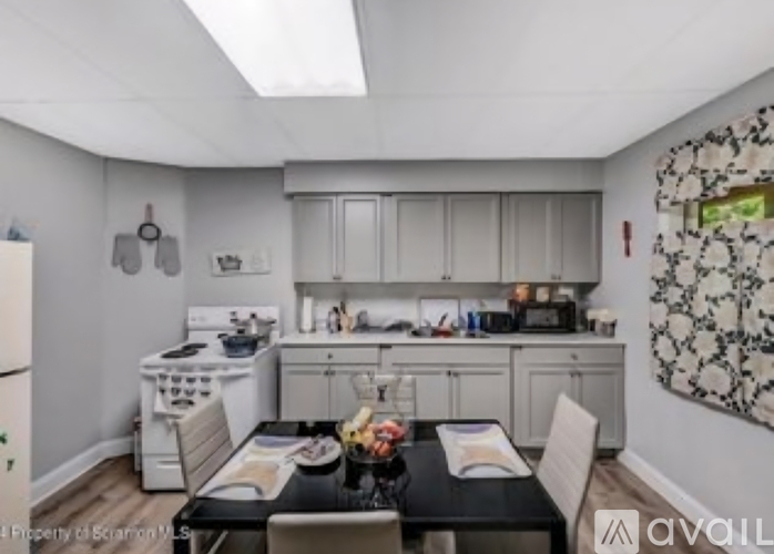 A kitchen with a dining table set for two.