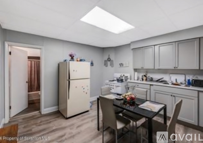 A kitchen with a table and chairs in the middle of the room.