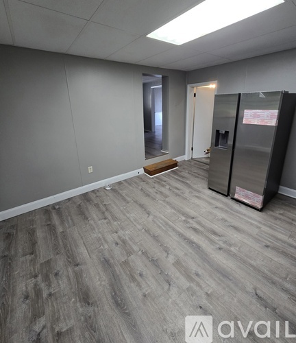 A bedroom with a bed, dresser, and window.
