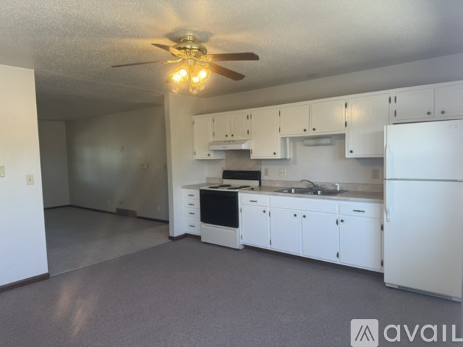 A kitchen with white cabinets and appliances is available for rent.