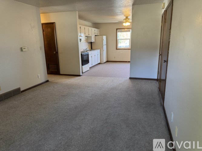 A spacious living area with a kitchen in the background.
