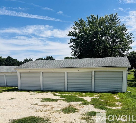 A row of garages with a tree in the background.