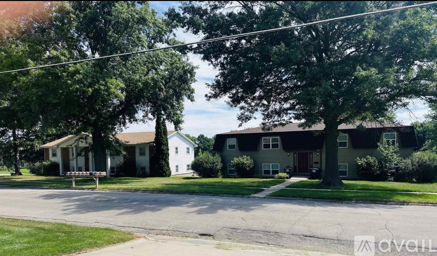 A street view of a residential area with houses and trees.