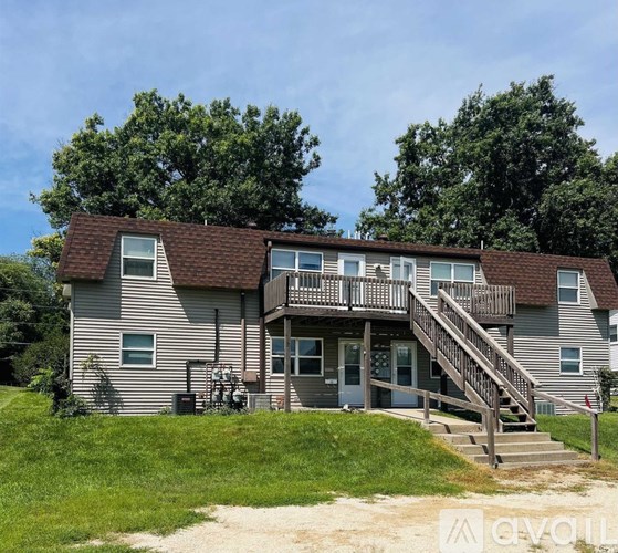 A house with a deck and stairs leading to the front door.