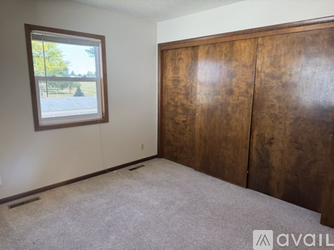 A room with a window and a wooden door.