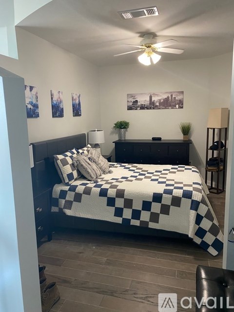 A bedroom with a bed covered in a black and white checkered comforter.