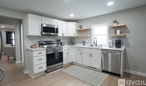 A modern kitchen with white cabinets and stainless steel appliances.