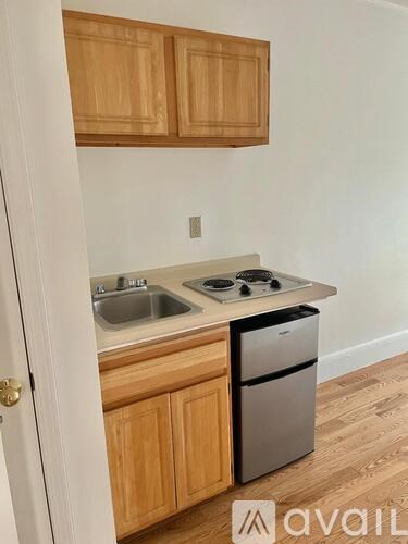 A kitchen with wooden cabinets and a stainless steel dishwasher.