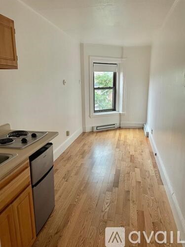 A kitchen with wooden floors and a window.