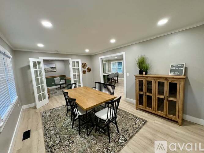 A dining room with a wooden table and chairs.