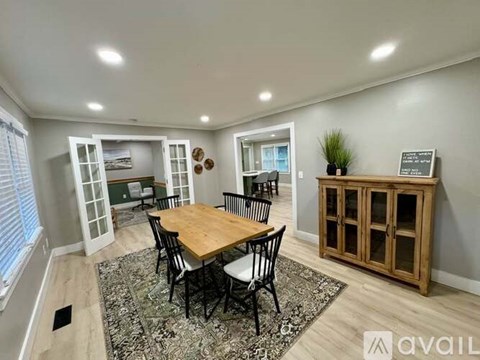 A dining room with a wooden table and chairs.