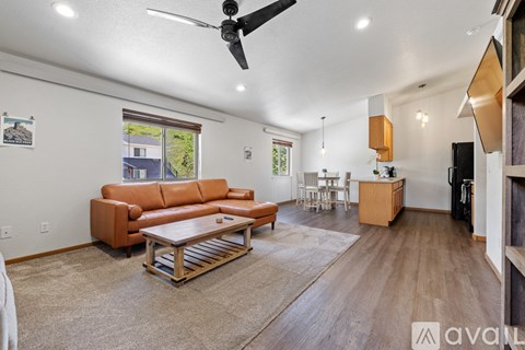 A living room with a brown leather couch and a wooden coffee table.