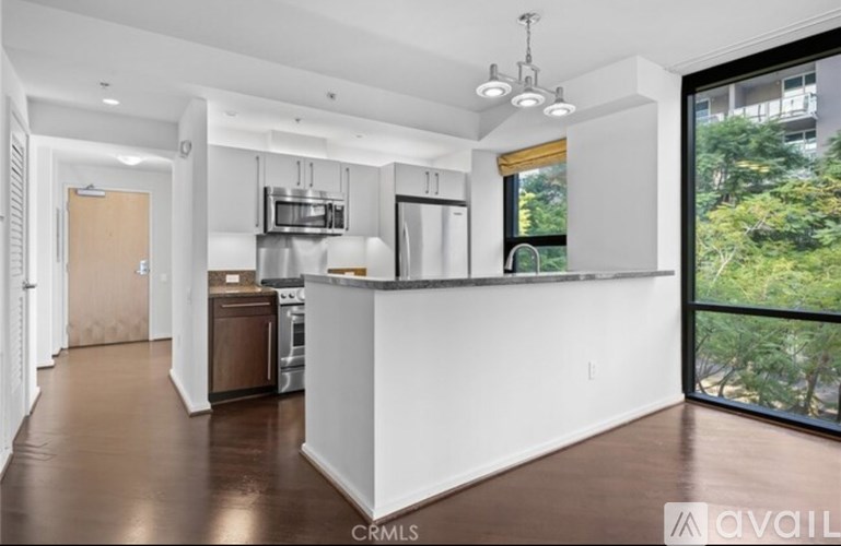 A kitchen with white cabinets and a brown floor.