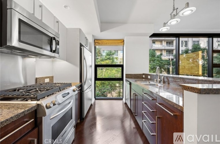 A modern kitchen with stainless steel appliances and wooden cabinets.