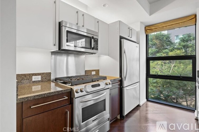 A kitchen with a stove top oven, microwave, and refrigerator.