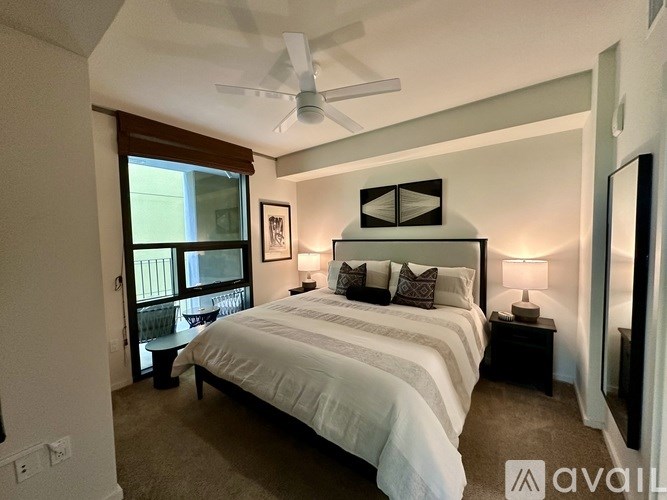 A bedroom with a large bed and a ceiling fan.