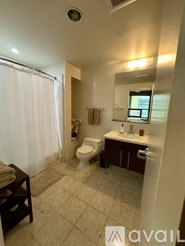 A bathroom with a toilet, sink, and mirror.