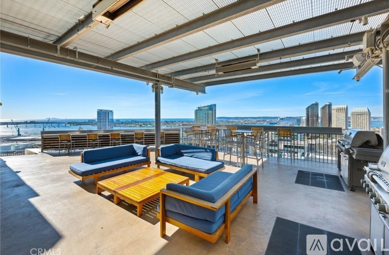 A rooftop patio with wooden furniture and a view of the city skyline.