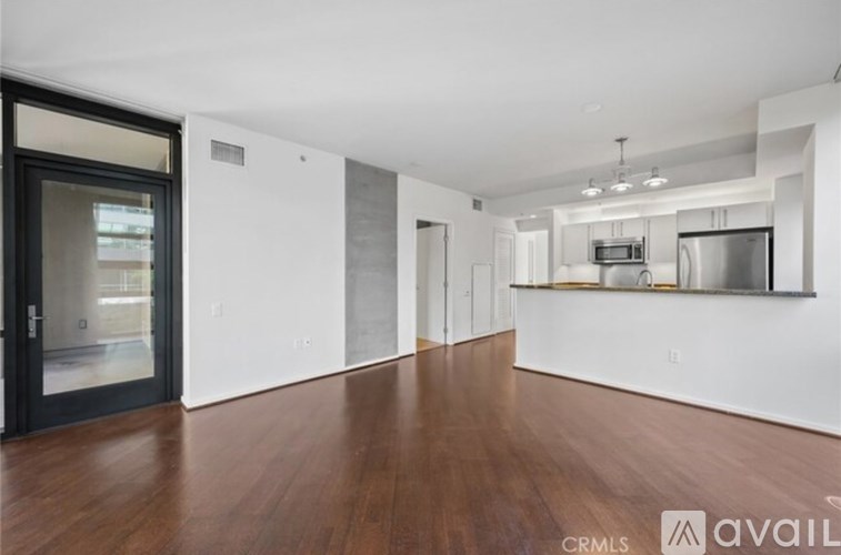 A spacious room with wooden floors and white walls.