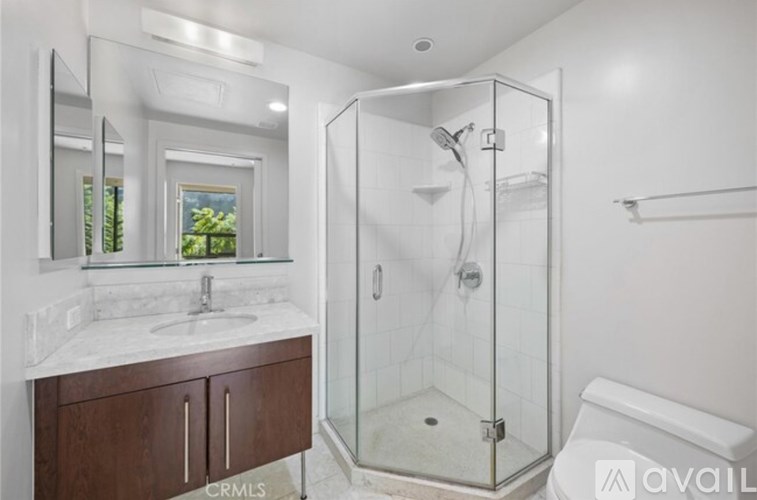 A bathroom with a walk-in shower and a large mirror above the sink.
