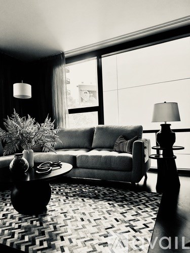 A black and white photo of a living room with a couch, chair, and coffee table.