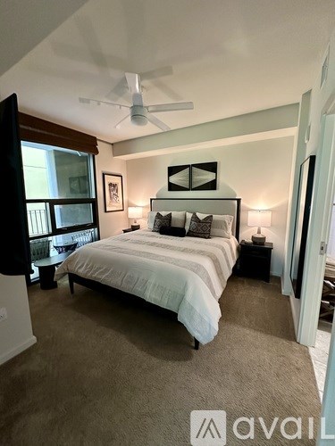A bedroom with a large bed and a ceiling fan.