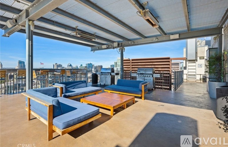 A patio with blue cushioned furniture and a view of the city.