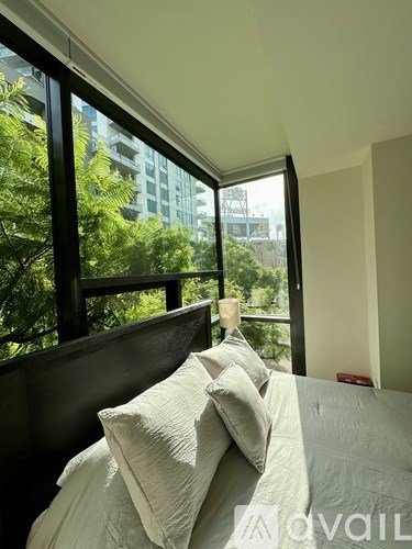 A bedroom with a large bed and a view of the city through the window.