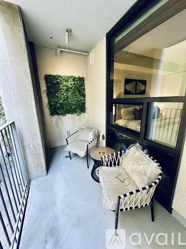 A balcony with a chair and a table with a bag on it.