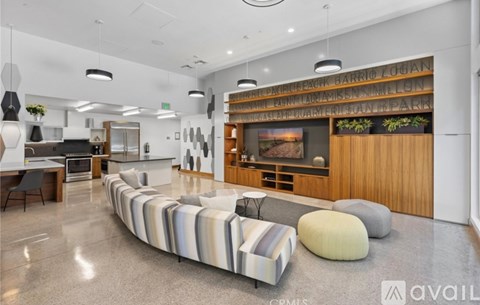 A living room with a long couch and a television mounted on the wall.