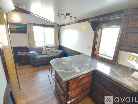 A living room with a grey couch and a marble counter.
