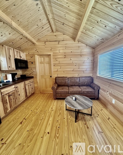 A wooden cabin interior with a couch and a coffee table.