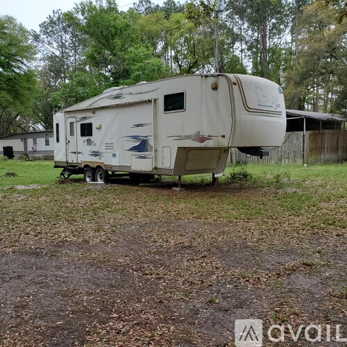 An old trailer is parked in a grassy field.