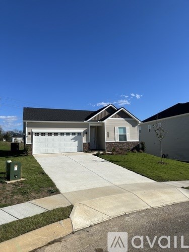 A house with a white garage door is shown in front of a clear blue sky.