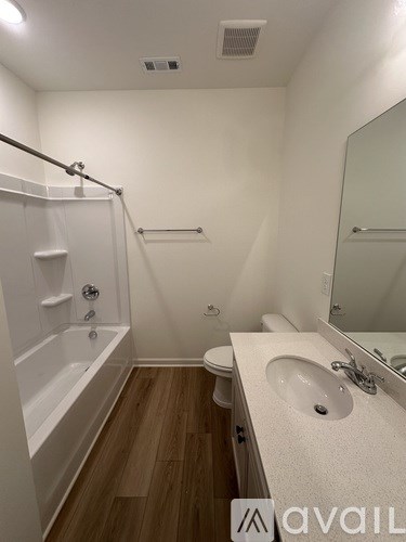 A bathroom with a white tub, sink, and toilet.