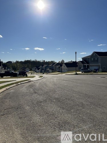 A sunny day in a residential area with houses on both sides of the street.