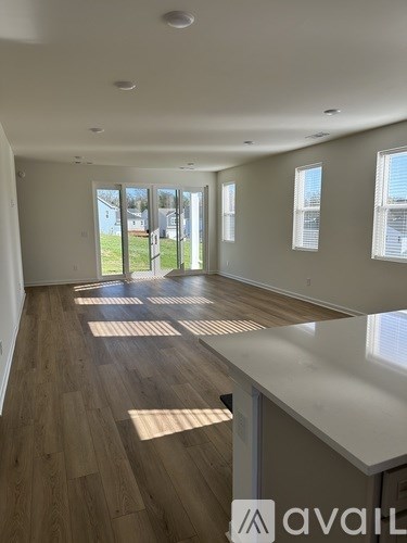 A room with wooden floors and large windows.