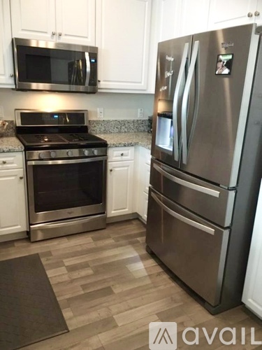 A modern kitchen with a stainless steel refrigerator and oven.