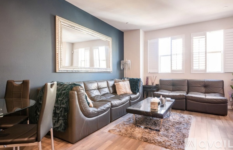 A living room with a brown leather couch and a glass coffee table.