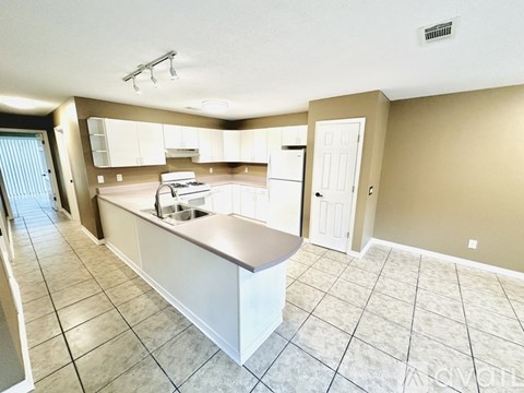 A kitchen with a white counter and a sink.