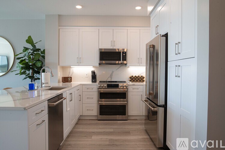 A modern kitchen with white cabinets and stainless steel appliances.
